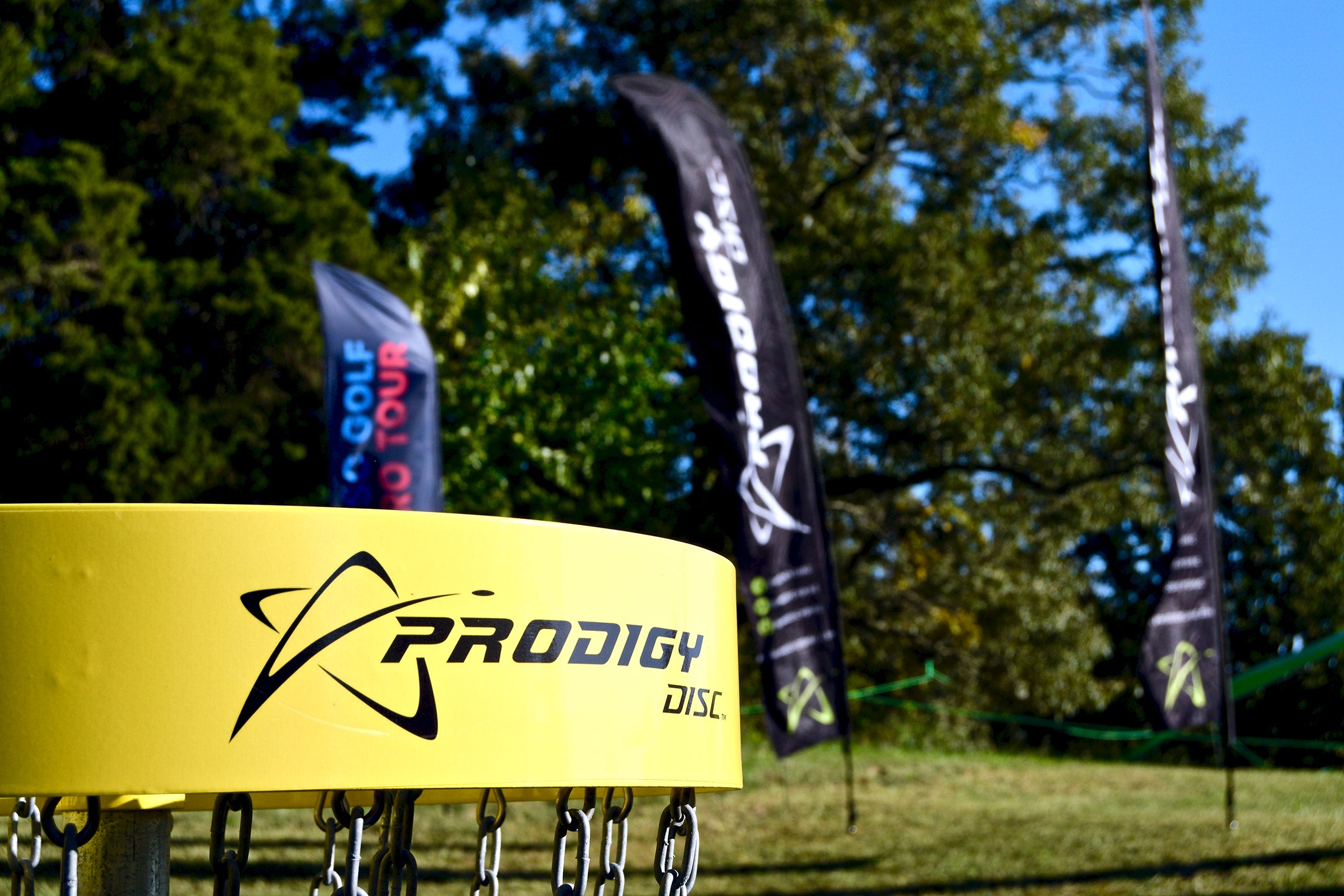 yellow prodigy disc golf basket on a disc golf course
